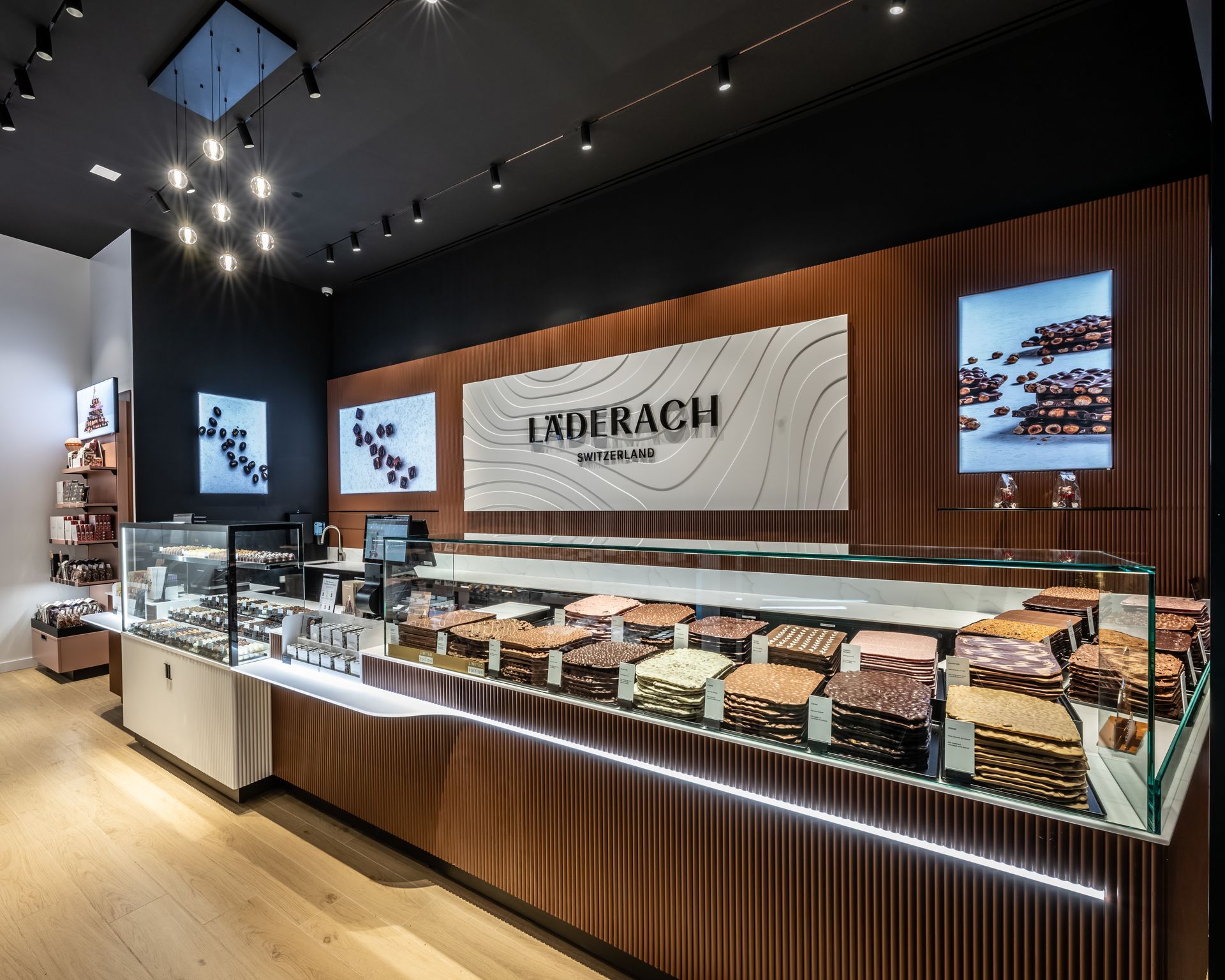 Modern bakery display with pastries, wood accents, glass cases, and illuminated menu screens
