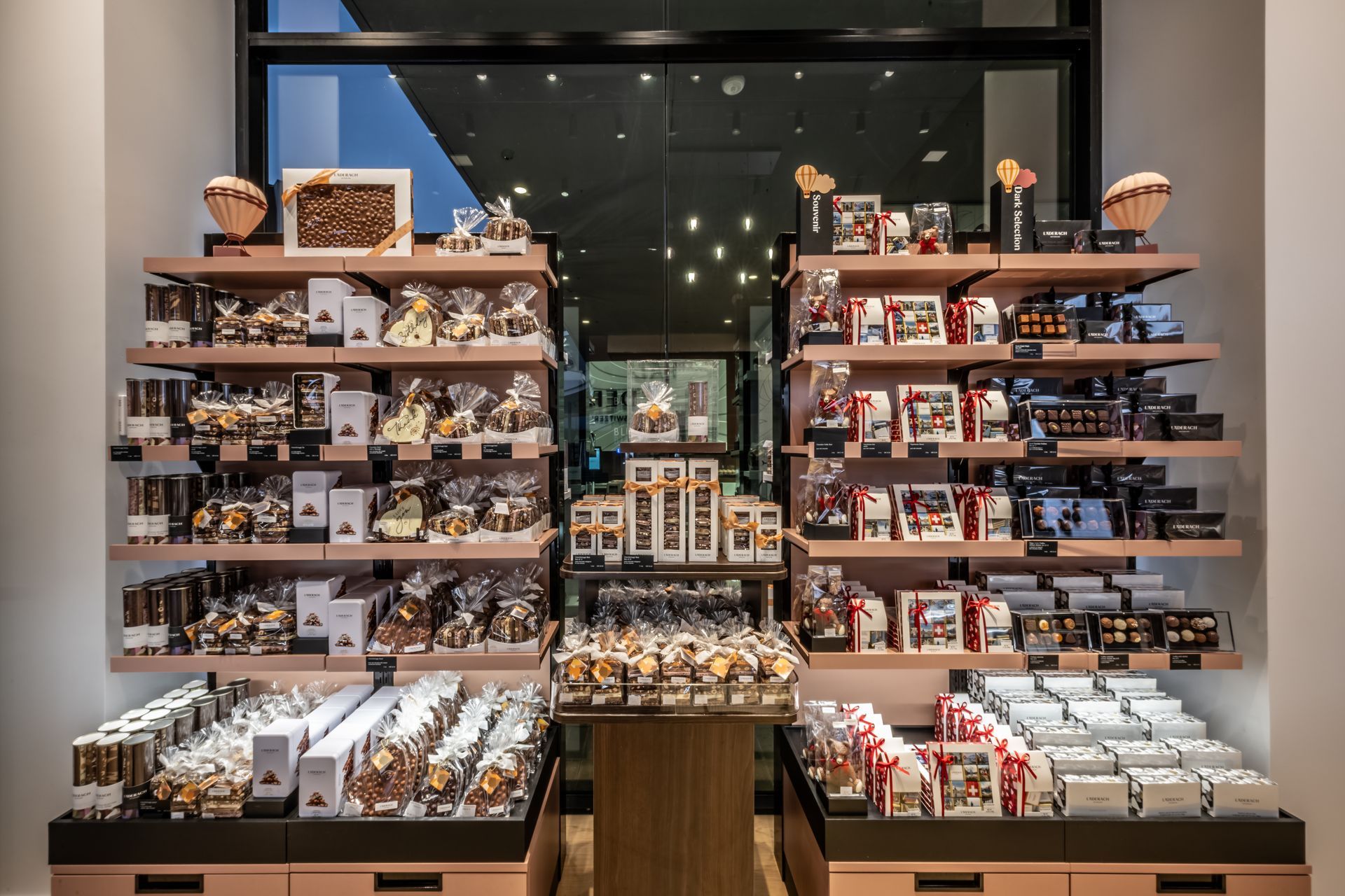Display shelves of assorted packaged goods and souvenirs in a well-lit shop interior