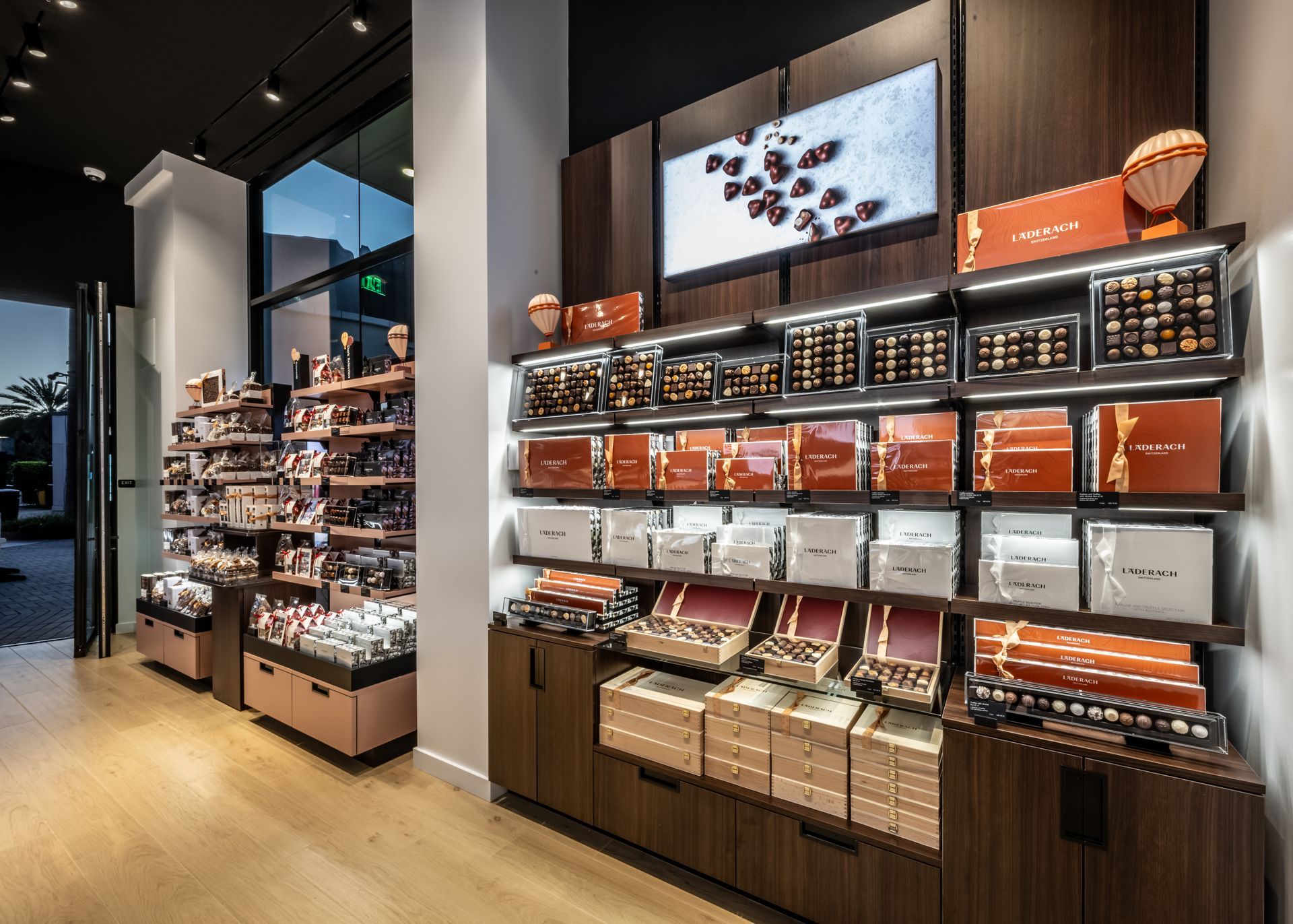 Modern retail store interior with shelves of boxed products and displayed accessories under warm lighting