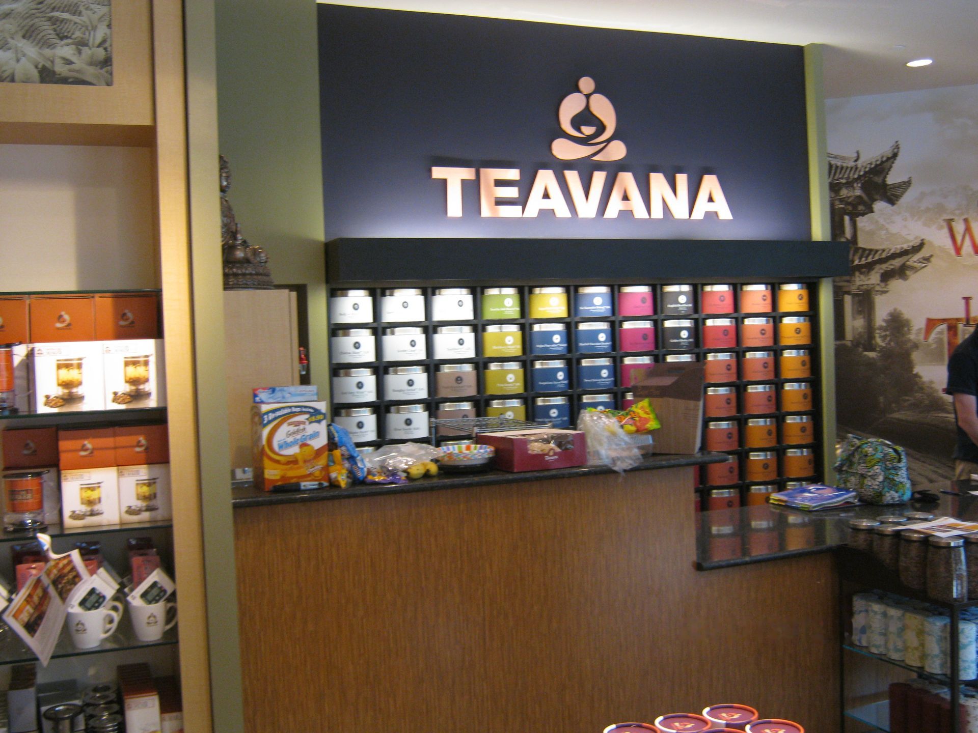 Teavana tea display with shelves of colorful tea tins and packaged products in a store kiosk