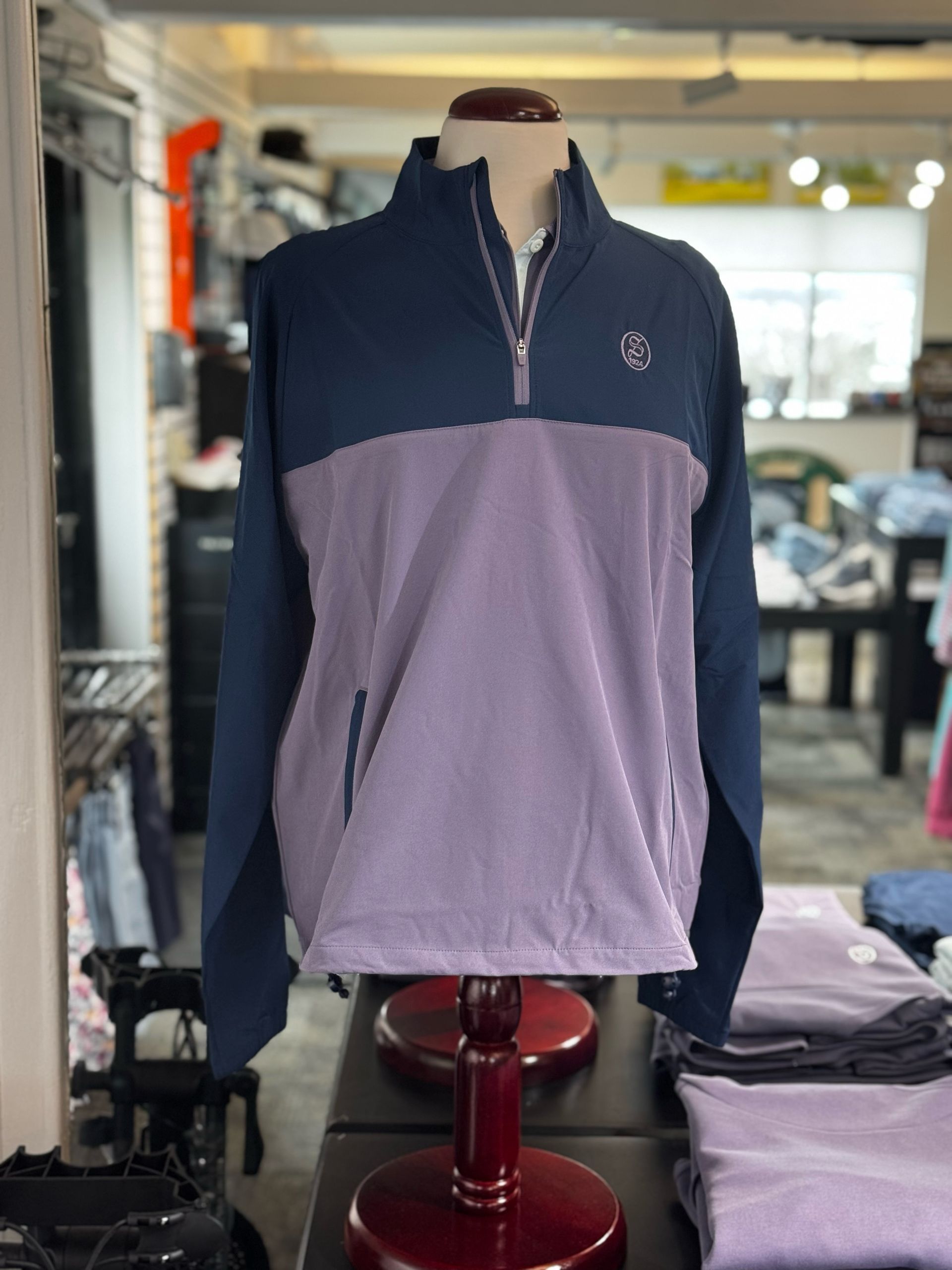Color-block fleece quarter-zip pullover on a mannequin in a clothing store