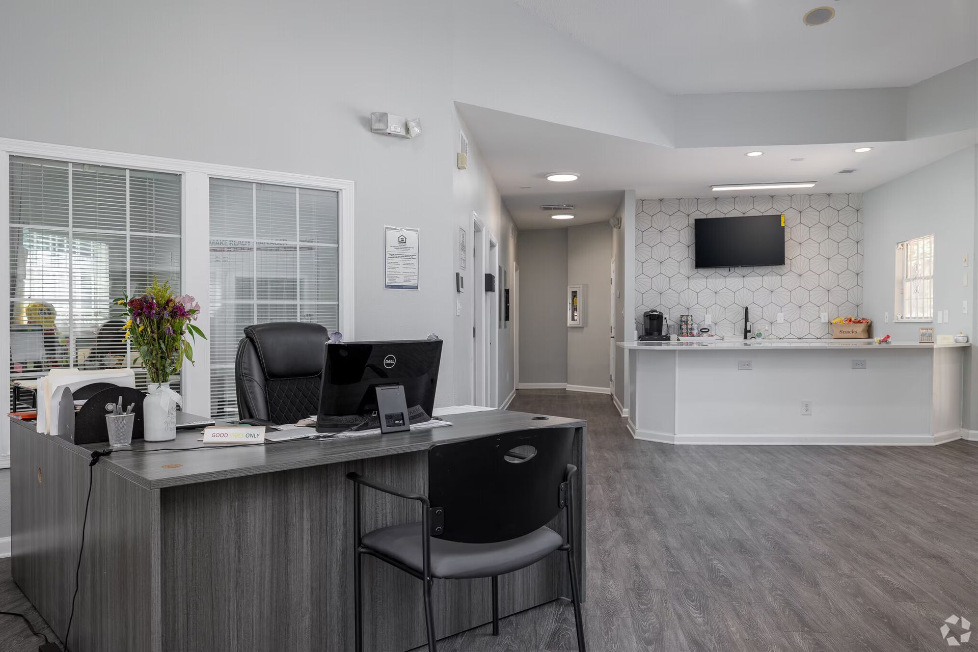 Photo of the interior of the community office showing a welcome desk with another desk in the background