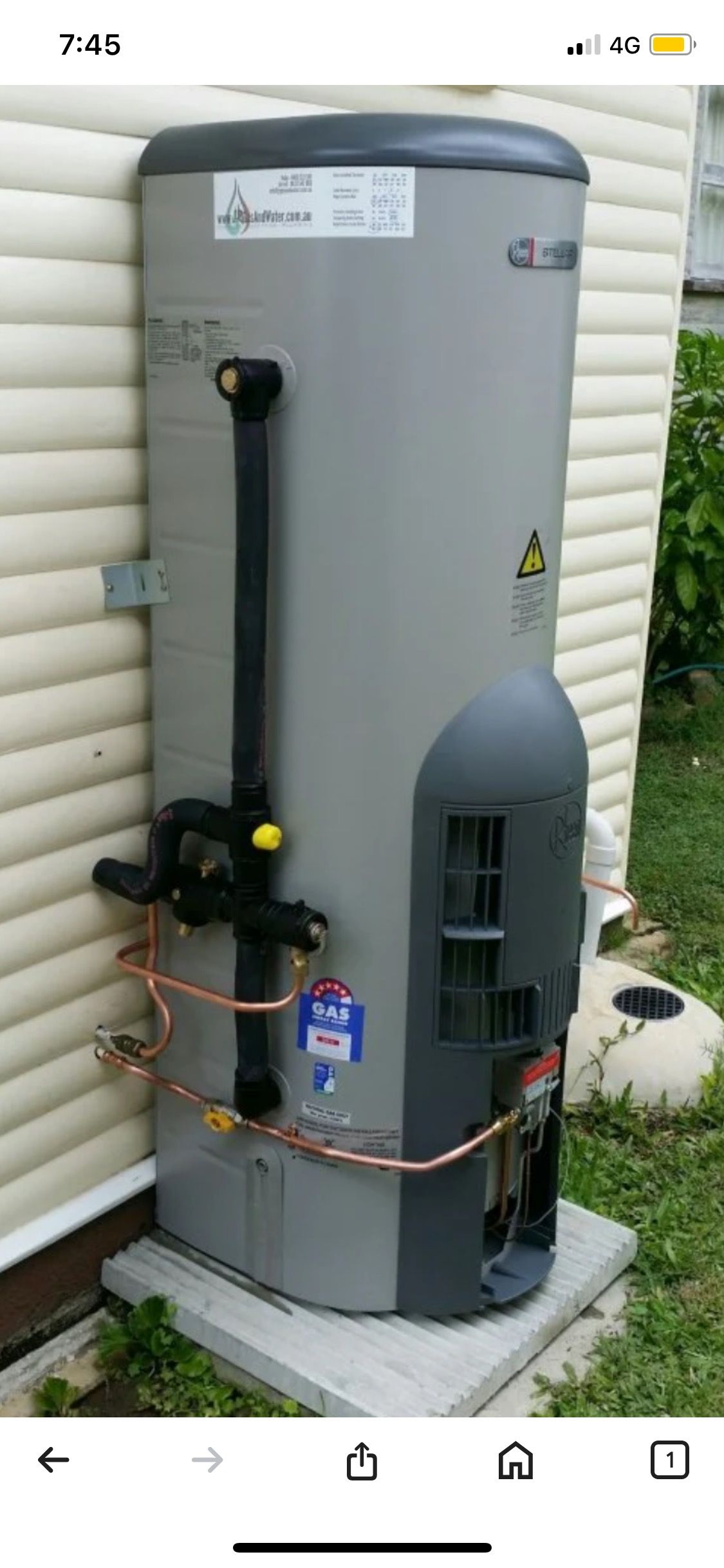 A Large Gray Water Heater is Attached to a Brick Wall — Corbett Plumbing in Ballarat, VIC