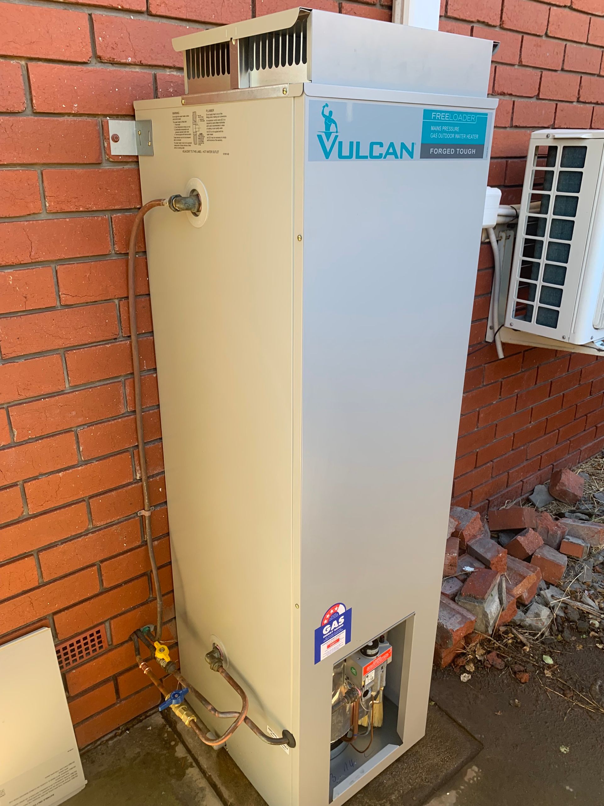 Two water heaters are sitting next to each other in a room — Corbett Plumbing in Ballarat, VIC