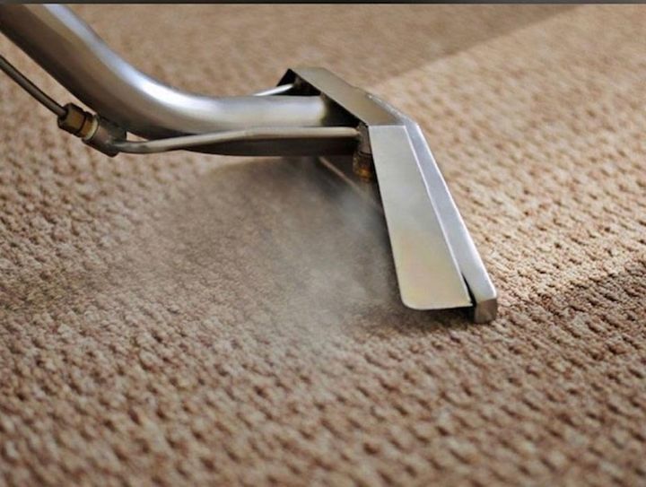A vacuum cleaner is being used to clean a carpet