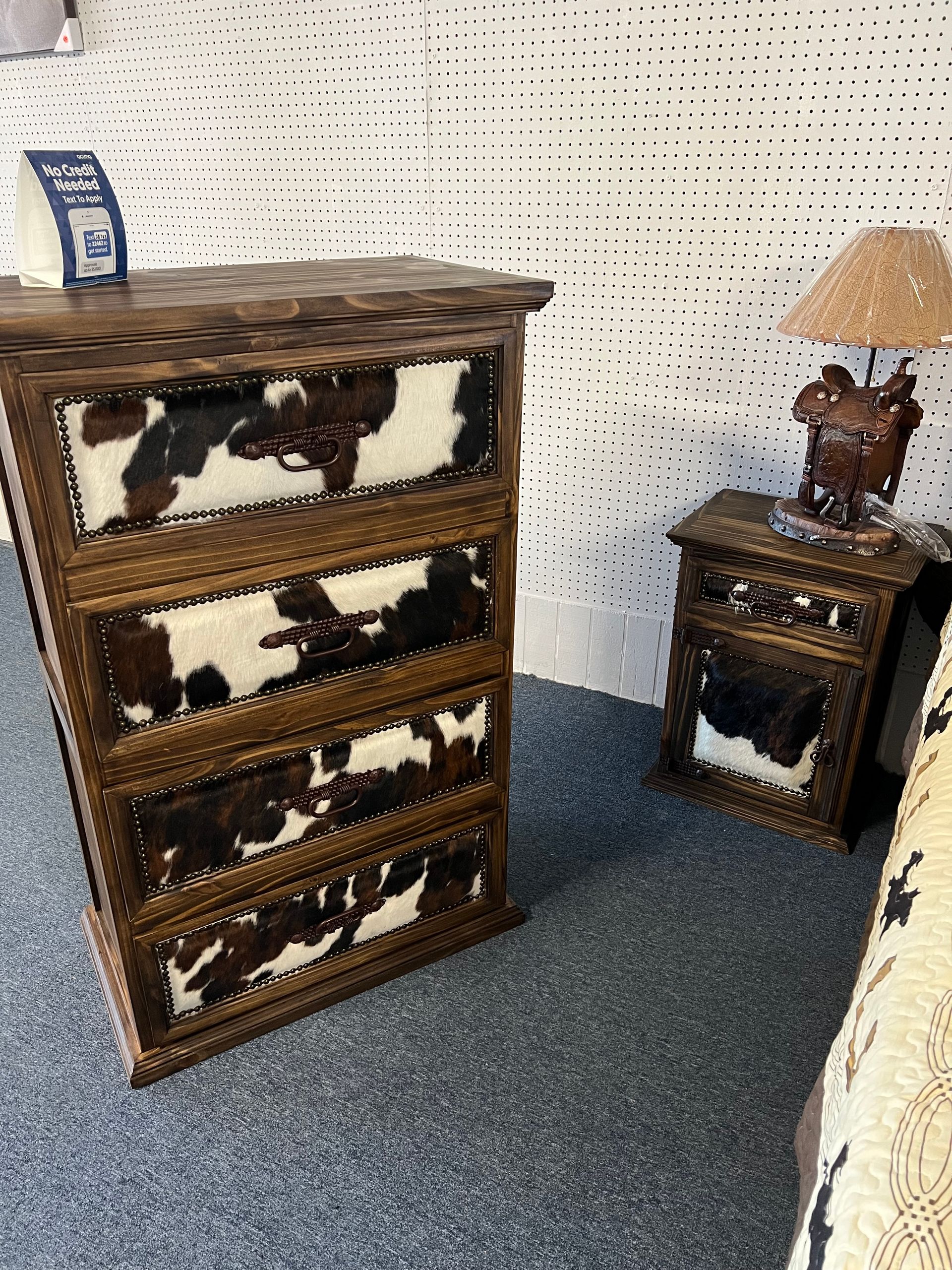 Western bedroom set: wooden bed, dresser, nightstands with cowhide accents.