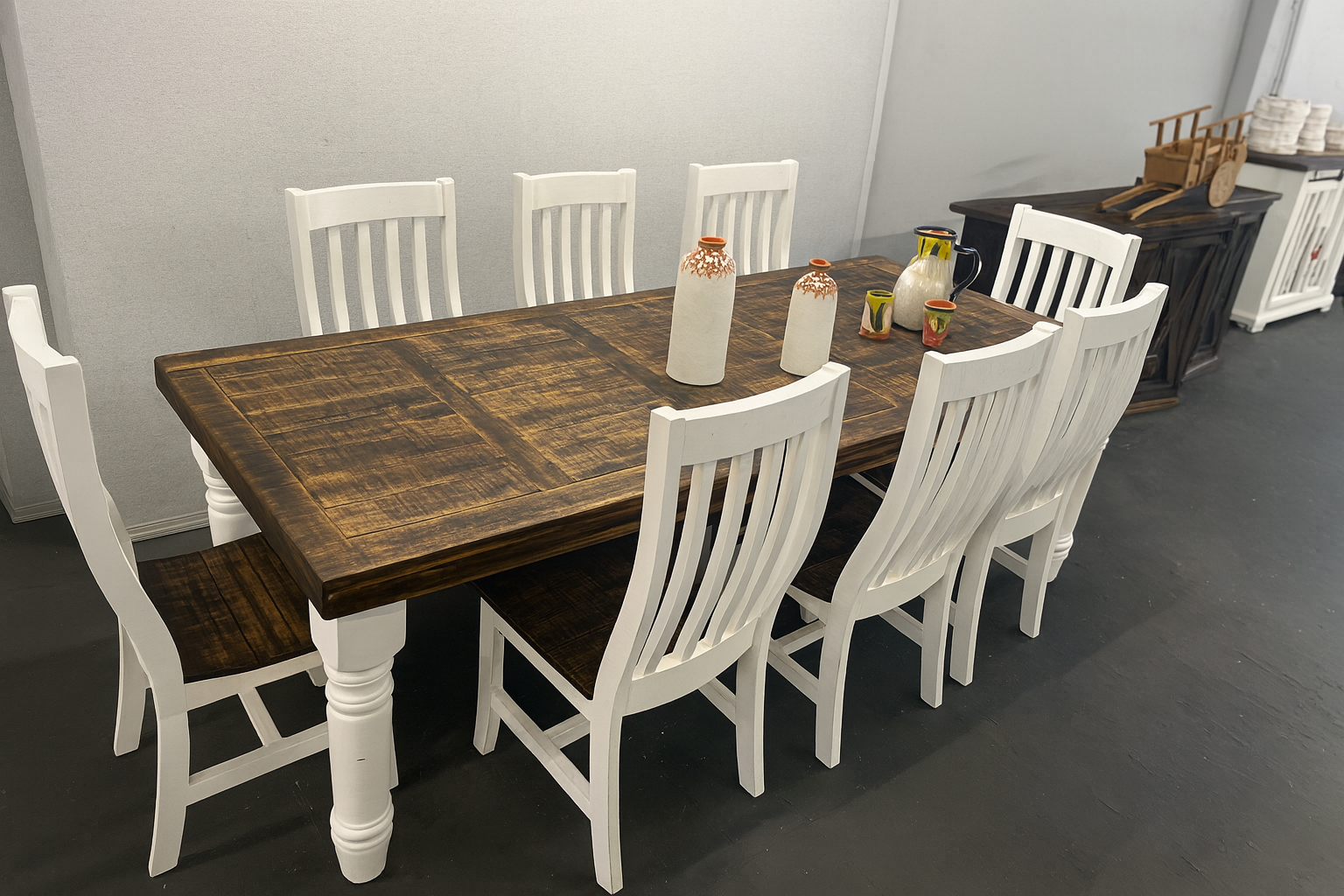 Dining room with a long, wood table, white chairs.