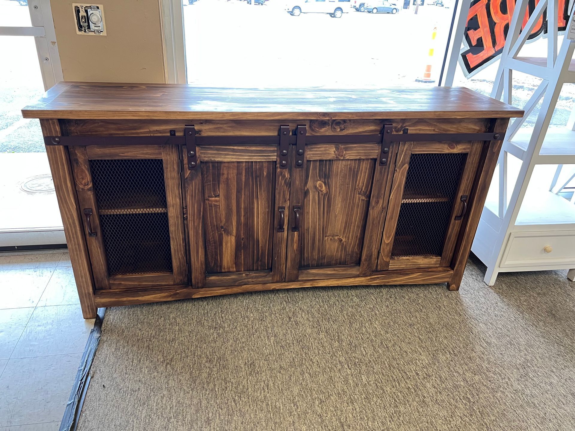 Wooden cabinet with sliding doors, mesh inserts, brown color, rustic style.