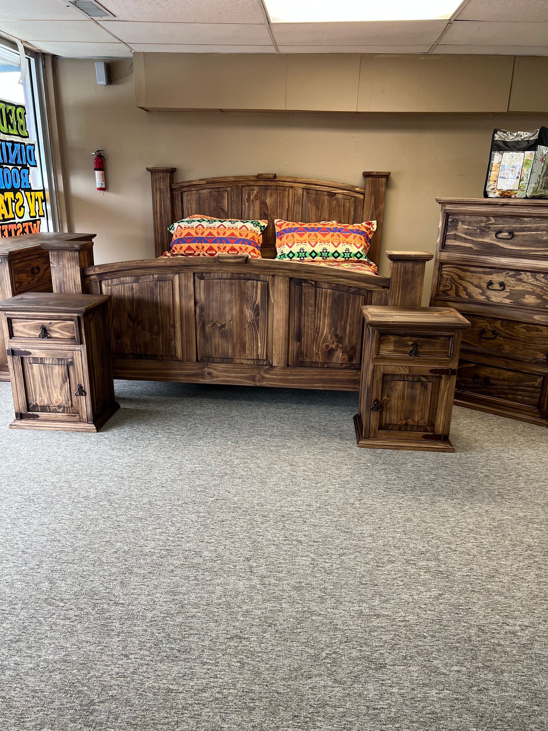 Rustic wooden bedroom set with bed, nightstand, dresser, and mirror; red accents.