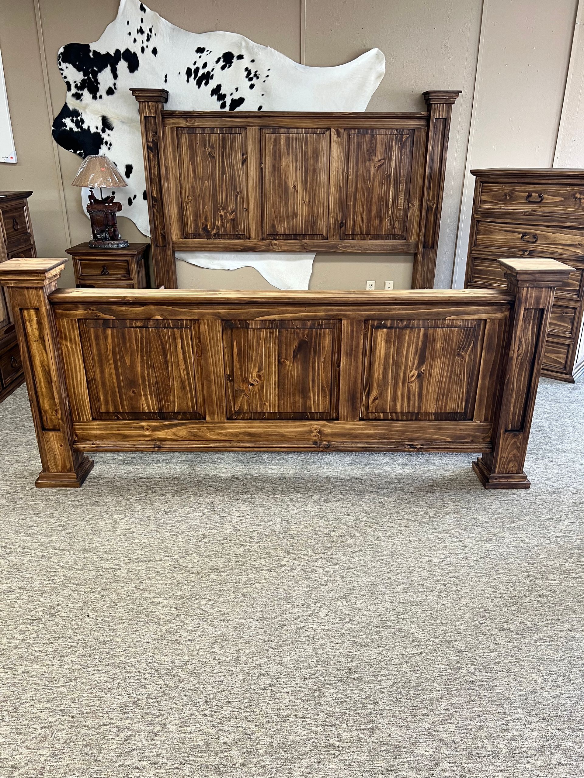 Rustic wooden bedroom set: bed, dresser, nightstand, and chest. The furniture has a dark wood stain.