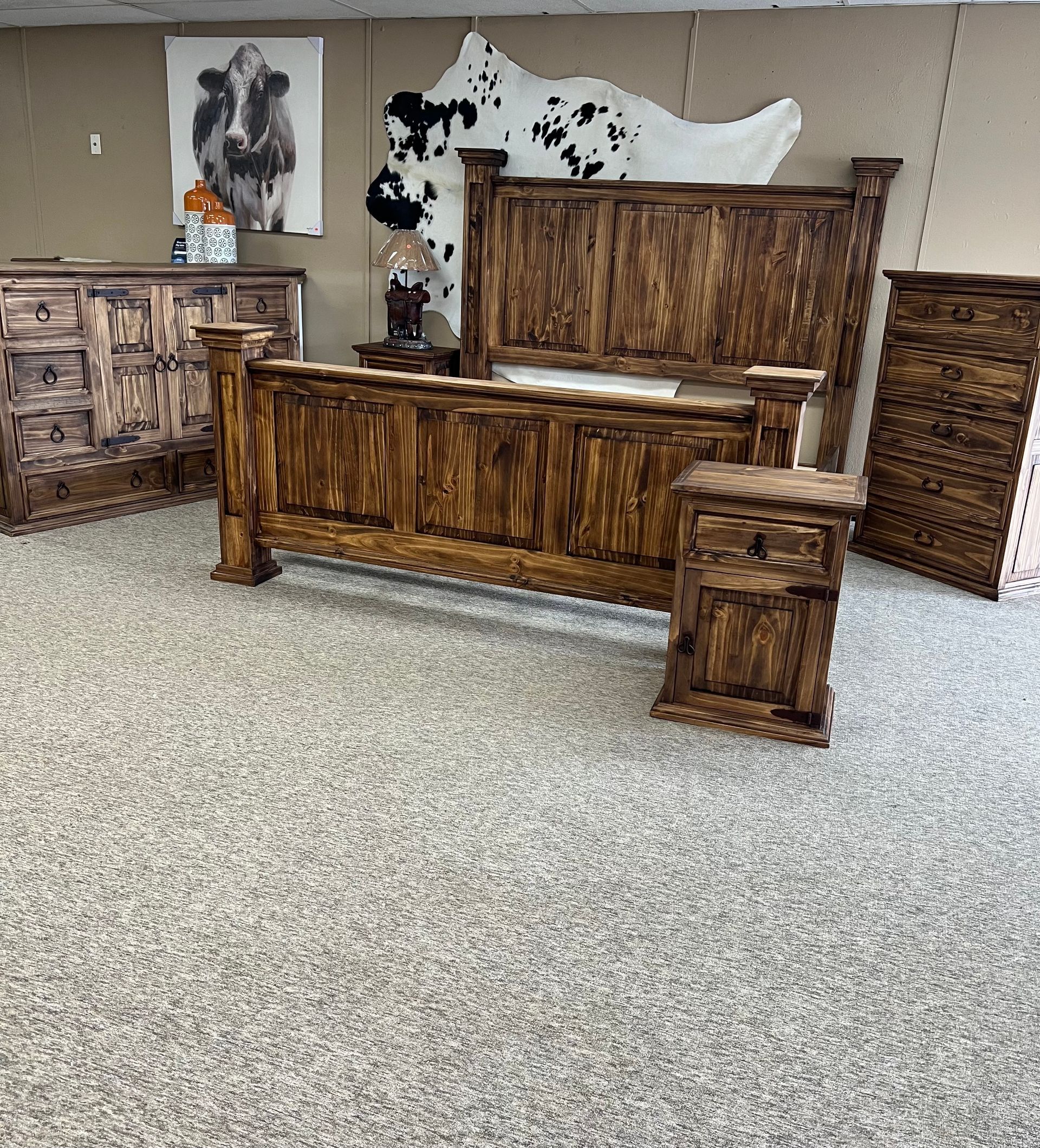 Rustic wooden bedroom set: bed, dresser, nightstand, and chest. The furniture has a dark wood stain.