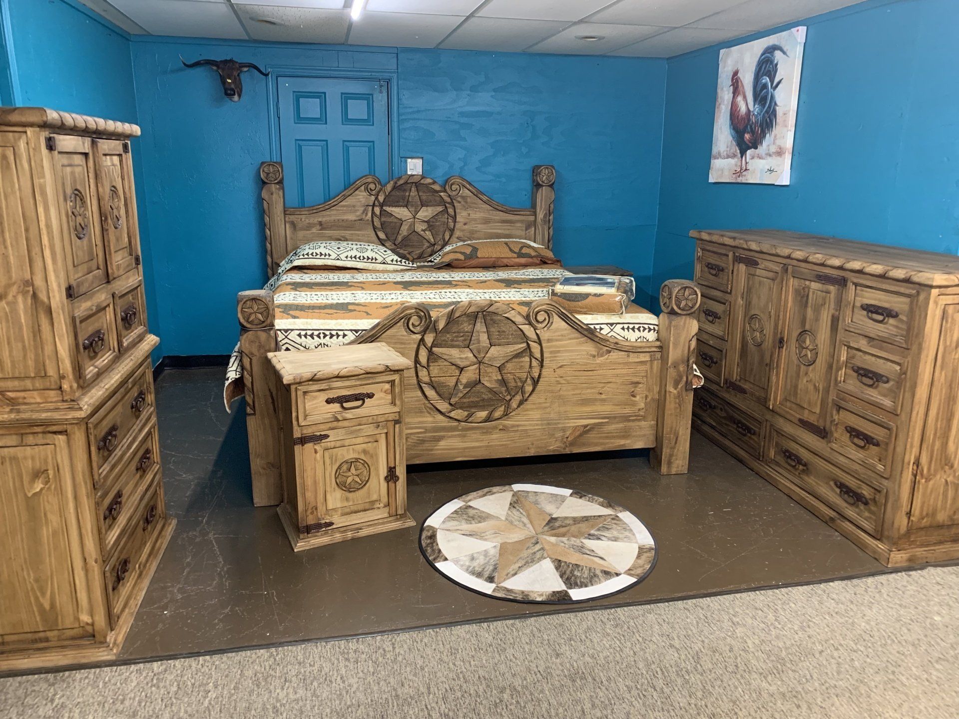 Bedroom with rustic wooden furniture and star accents; blue walls, carpet, and art.