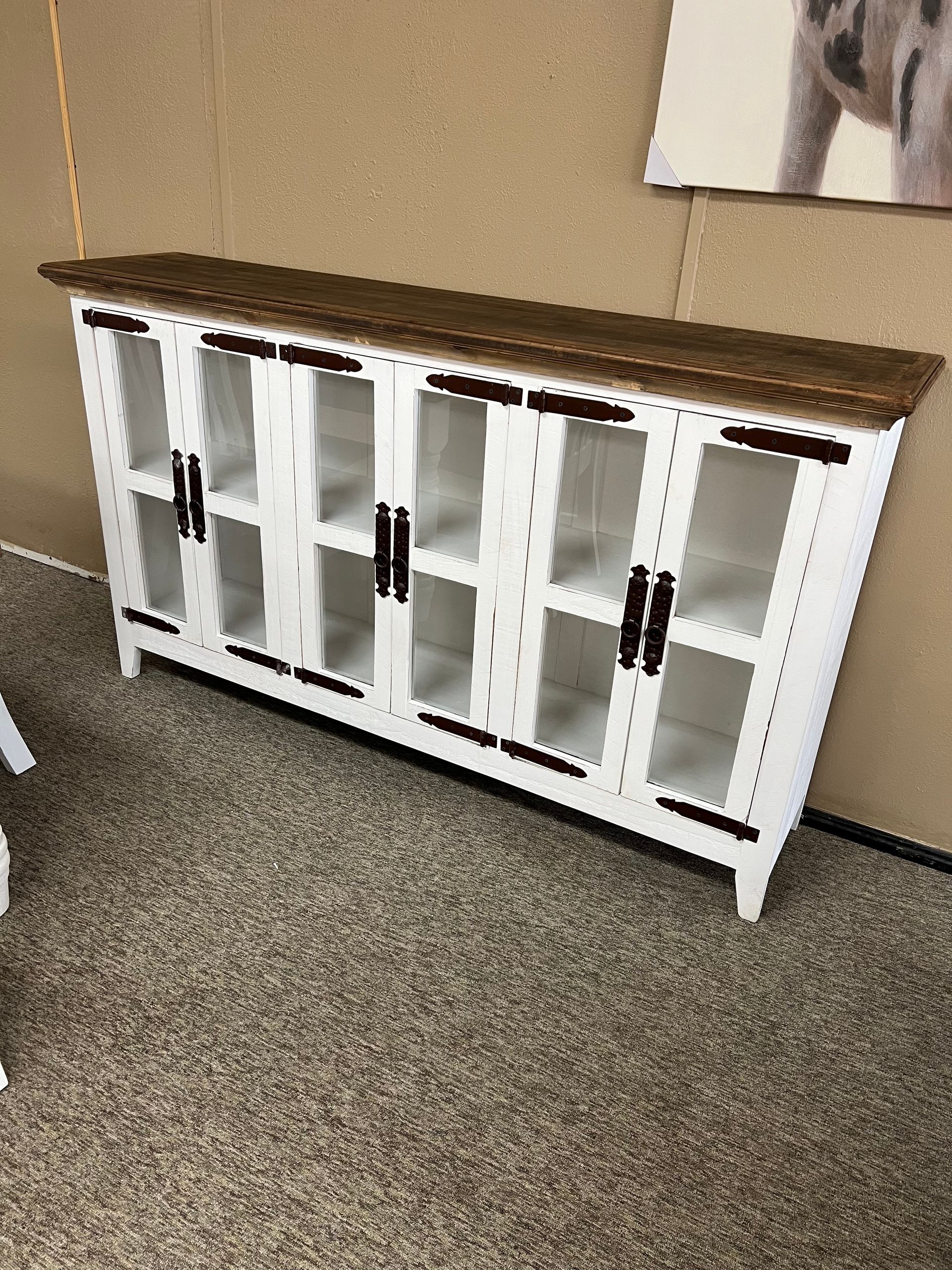 White and brown cabinet with glass doors, on a brown carpet.