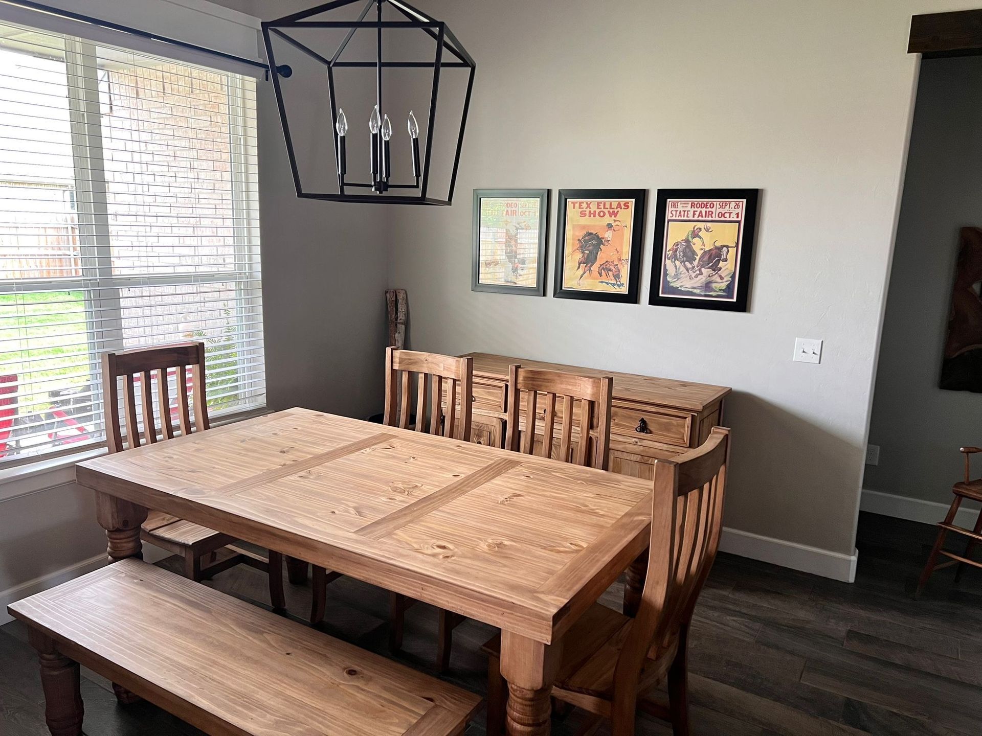 Wooden dining room set with a hutch against a gray wall, near a sliding glass door.