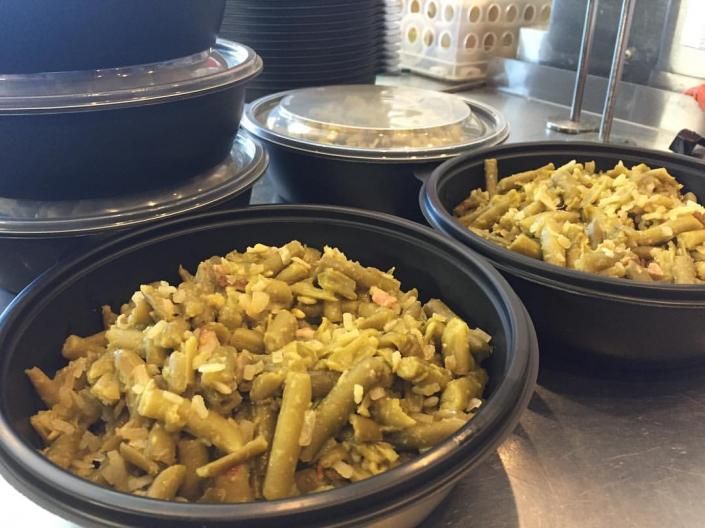 Bowls of stir-fried vegetables on a stainless-steel counter in a kitchen or buffet line