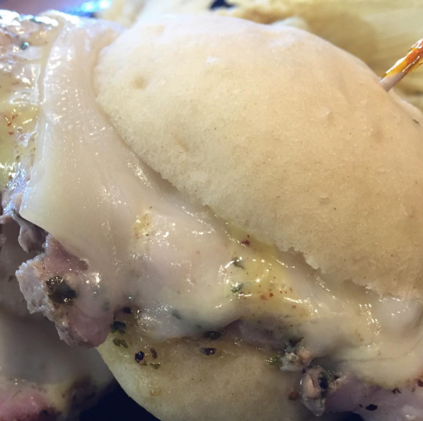 Close-up of a cheeseburger with melted cheese and a soft bun, showing a juicy patty underneath