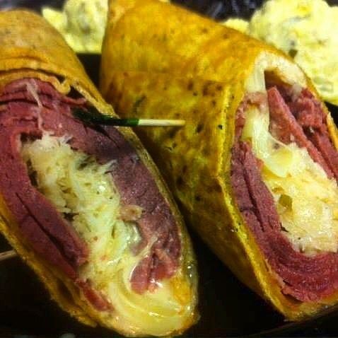 Two cut wraps with yellow tortillas, red filling, and melted cheese on a tray