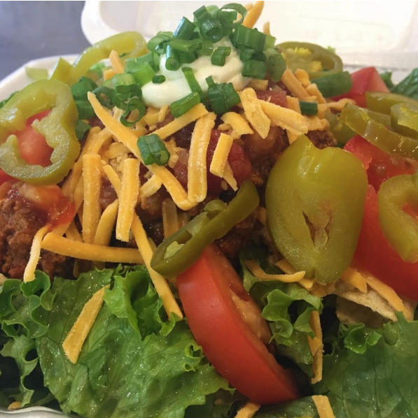 Fresh salad with lettuce, tomatoes, green peppers, shredded cheese, and chopped green onions