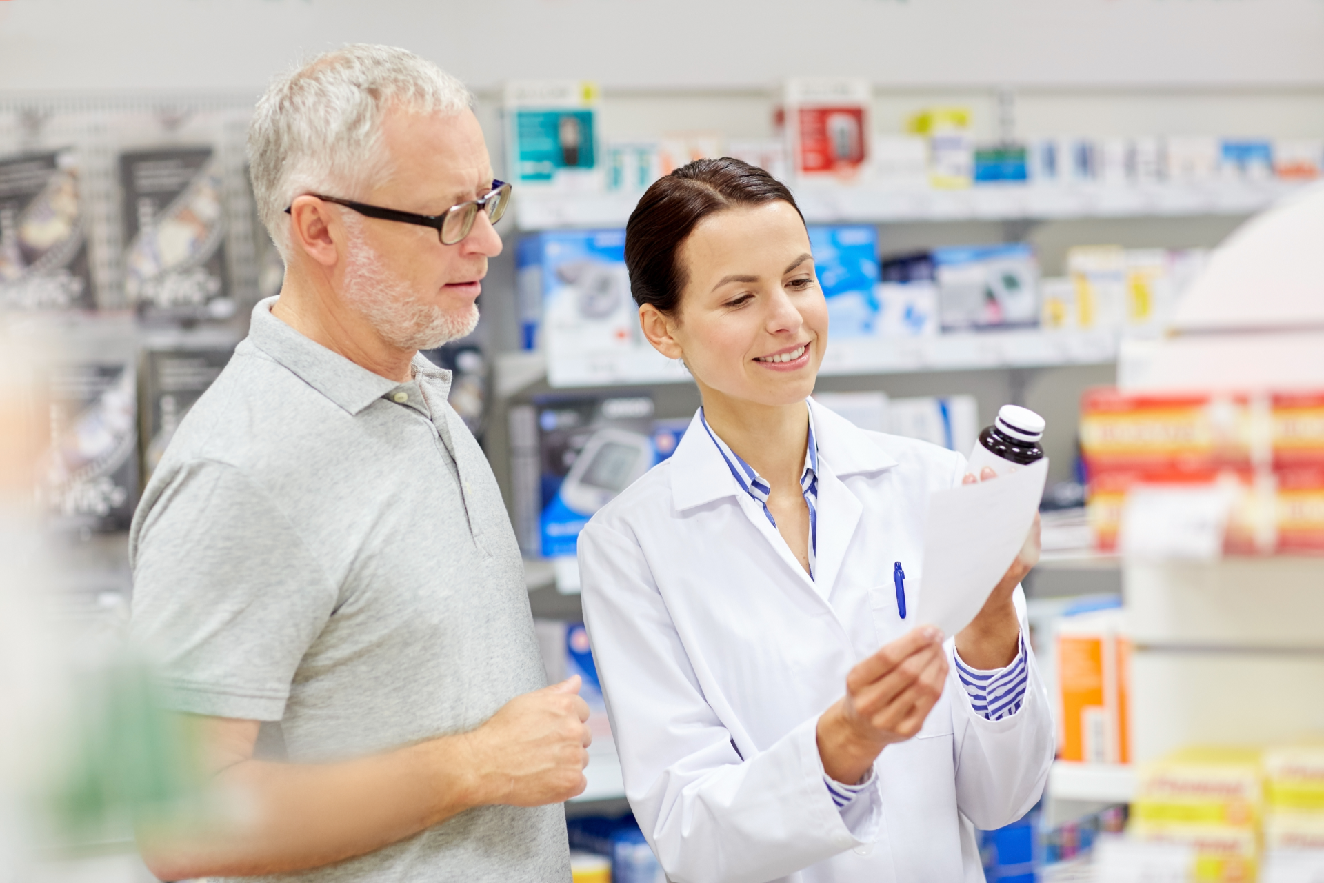 Pharmacist showing prescription to a customer in a pharmacy.