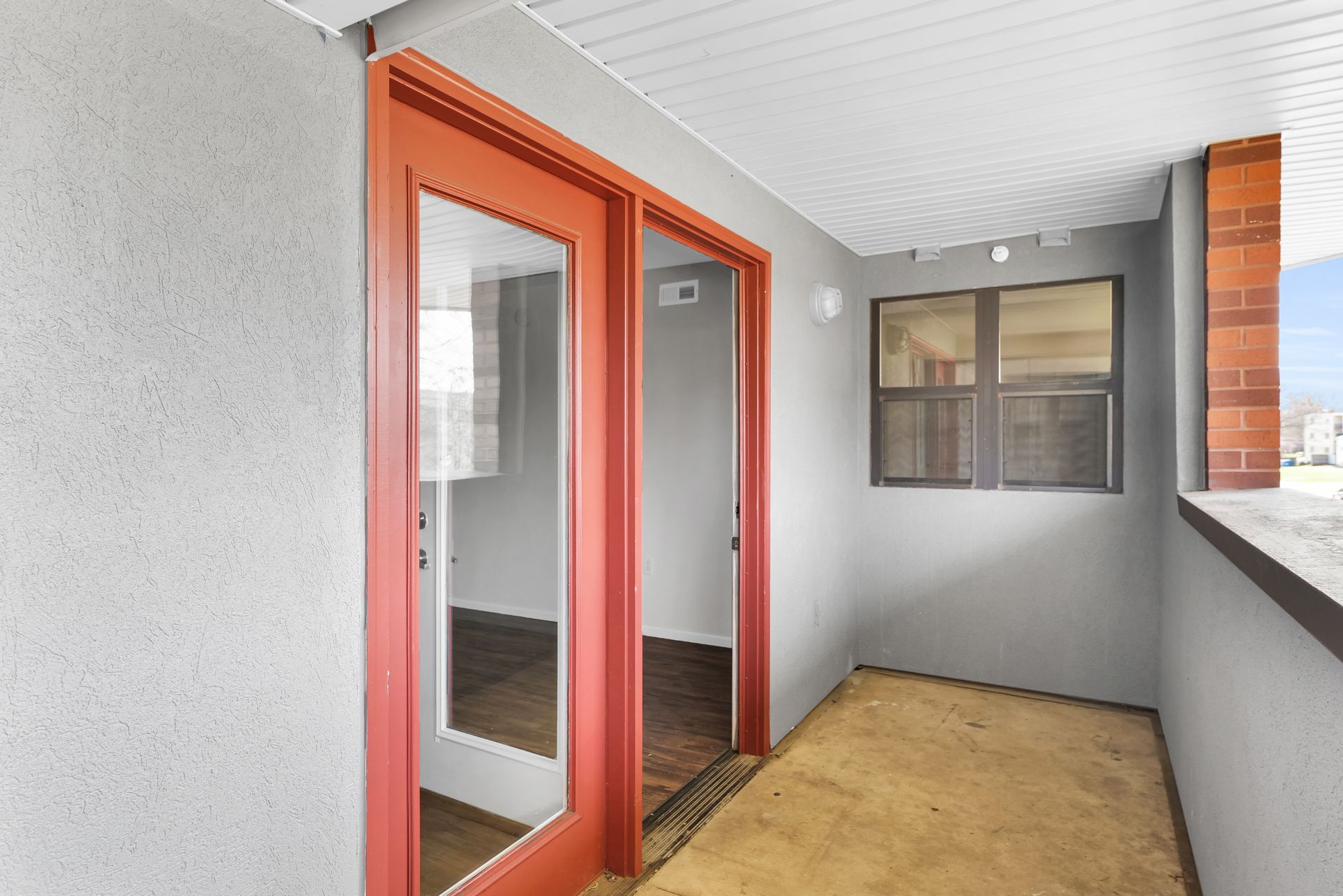 A balcony with sliding glass doors and a window.