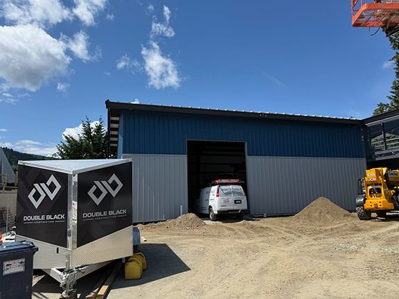 Double Black Construction trailer in front of building site.