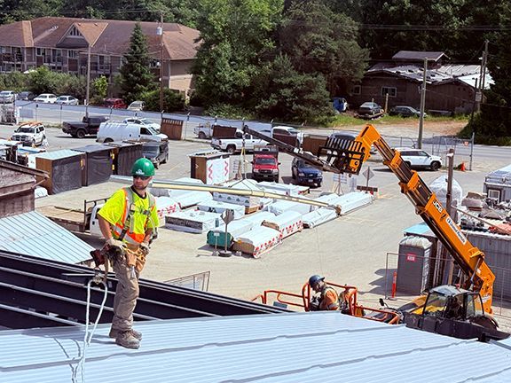 Construction worker stands on top of the Windsor Plywood building on Salt Spring Island, B.C.