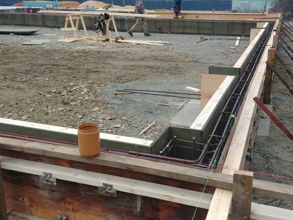 A concrete wall is being built on a construction site.