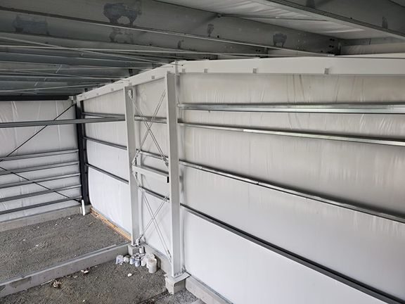 The inside of a building with white walls and metal beams.