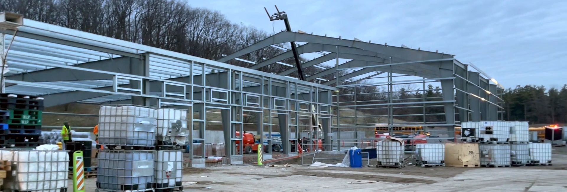 A large metal structure is being built in a field.