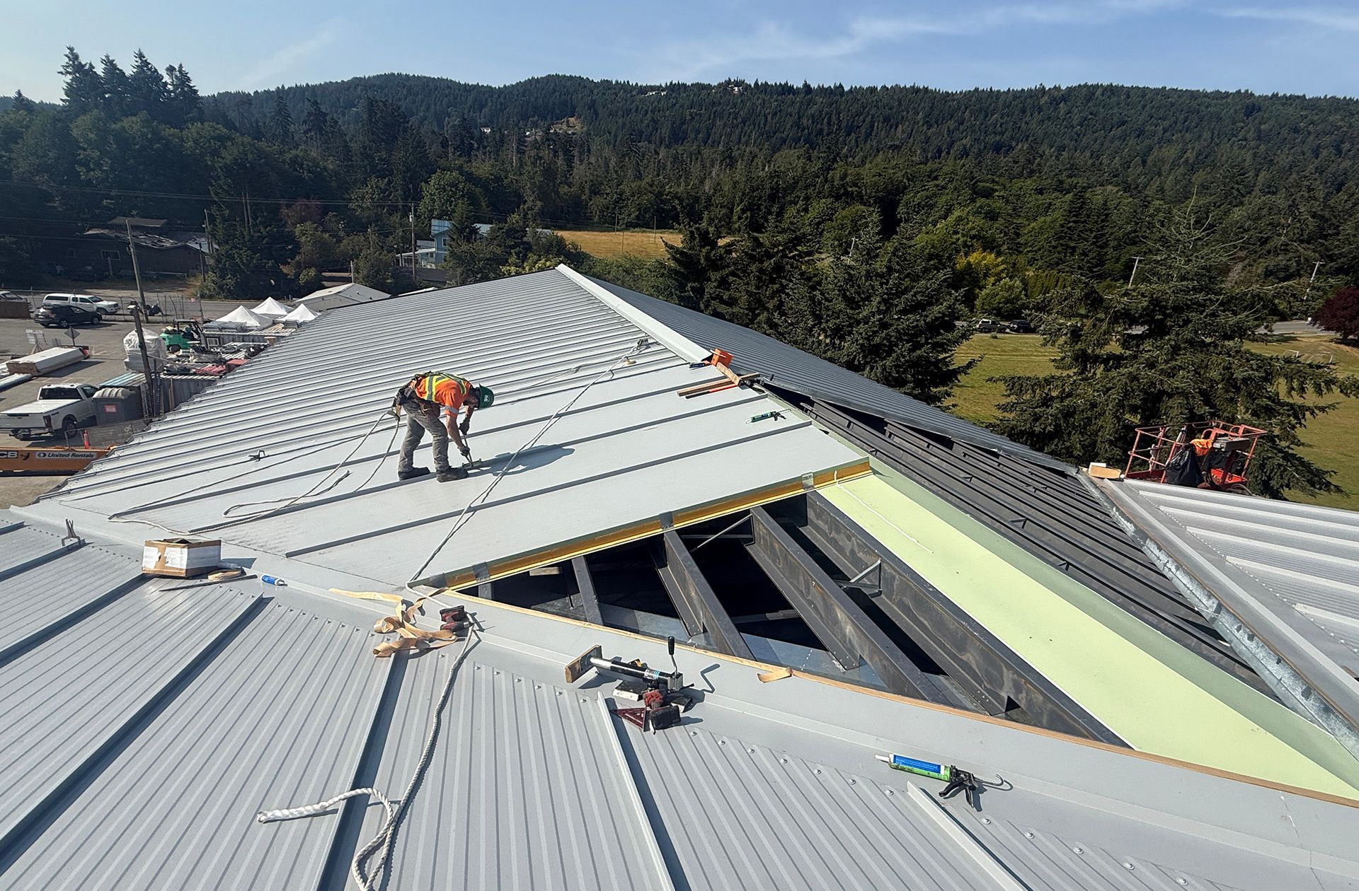 Skilled tradesman installs an insulated roof panel at construction site.