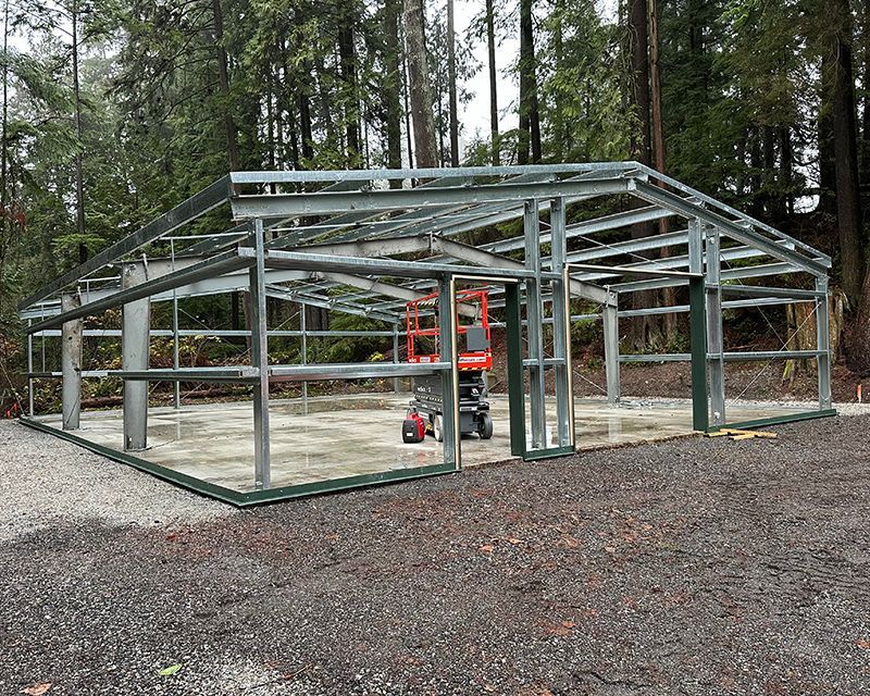 A large metal structure is being built in the middle of a forest.