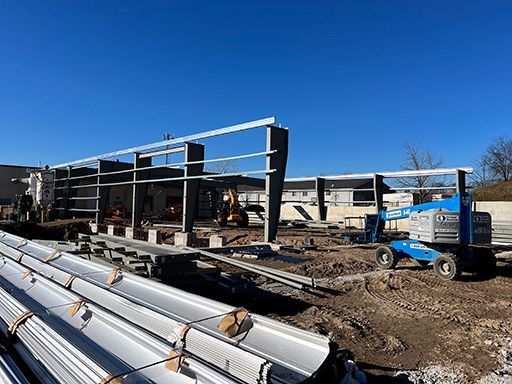 A large building is being built with a lot of machinery in the background.