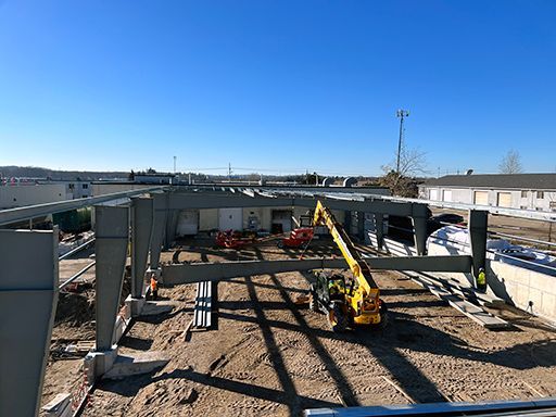 A large metal structure is being built on a construction site.
