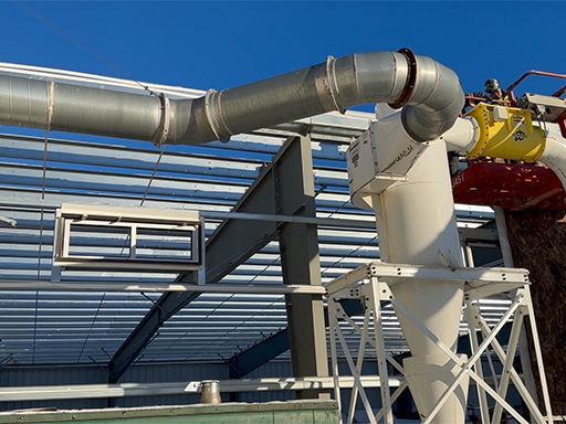 A large pipe is hanging from the roof of a building.
