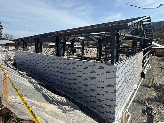 Waterproofing being added to pre-engineered building construction.