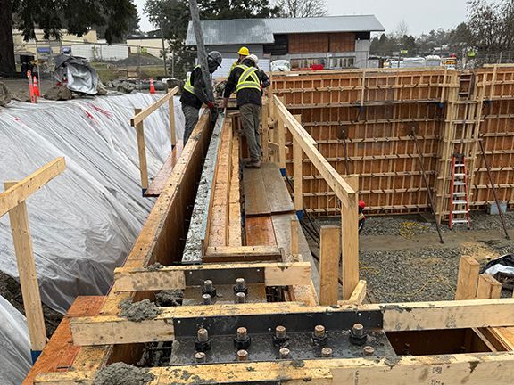 Skilled tradespeople pour concrete into wooden forms on Salt Spring Island.