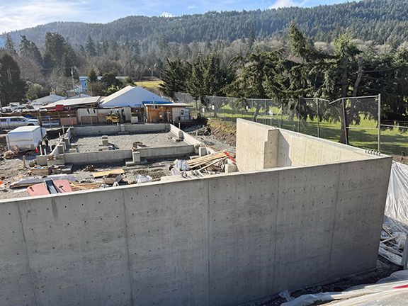 View overlooking concrete wall at rest of metal building foundation construction work in British Columbia by Double Black Construction.