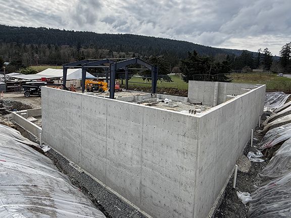 Metal building framing is complete as viewed from one end of the construction site in Salt Spring Island, British Columbia.
