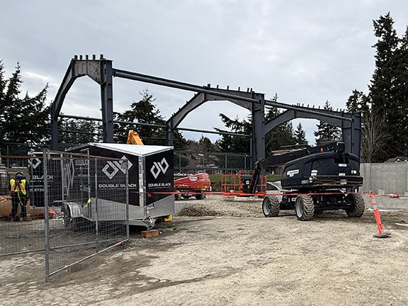 Side view of a metal building construction site, showing initial steel frame.