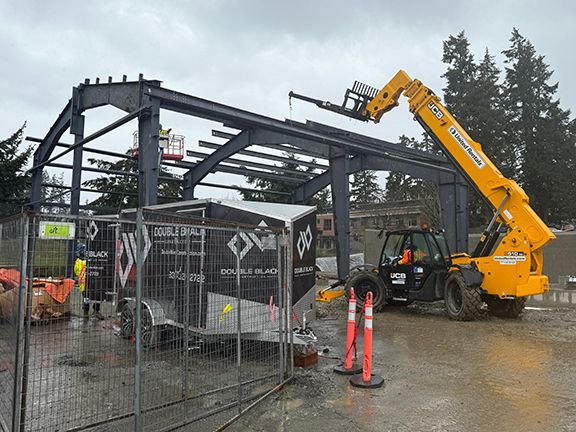 Roof supports being added to steel frame for Windsor Plywood warehouse project in BC.