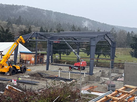 Side view of steel frame and roof trusses at construction project on Salt Spring Island in British Columbia.