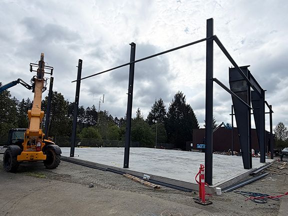 Photo shows how primary steel framing is supported by concrete foundation.