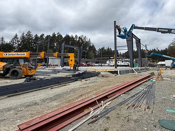 Steel I-beam sits nearby PEMB construction jobsite ready to be installed