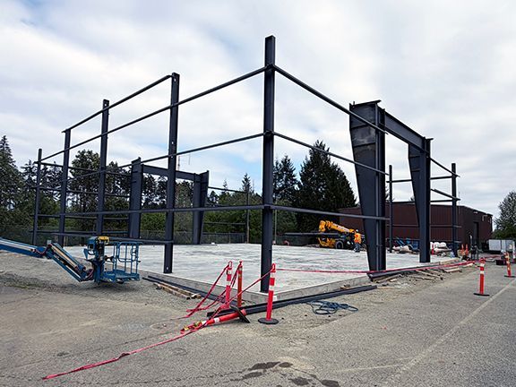 Steel I-beam framing and concrete foundation pad work together.