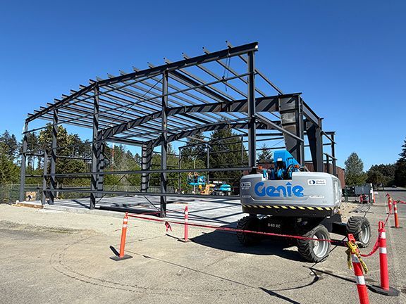 Roofing crossbeams are added to steel framework at industrial building project