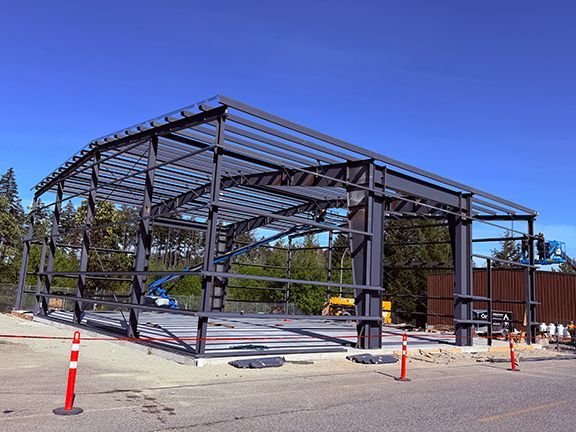 Roof and wall framing sits atop a concrete pad for building project.
