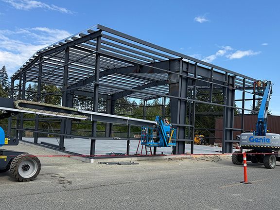 Metal wall panels being added to wall framing at PEMB project.