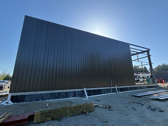 One side of industrial steel building finished with metal wall panels