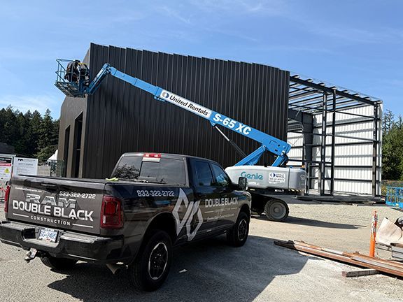 DBC truck in front of metal wall panel installation at PEMB project.