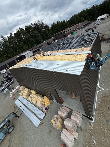 Aerial view of roof panels being added to PEMB project.